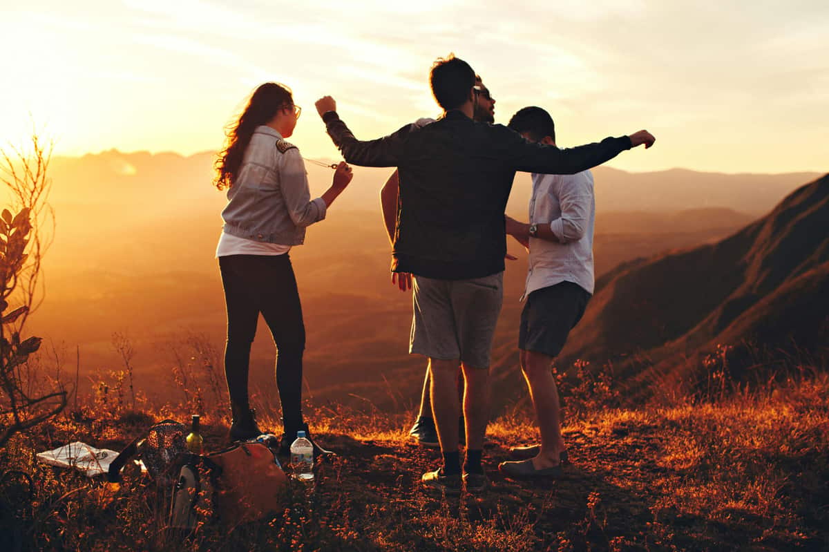 Friends standing together at sunset